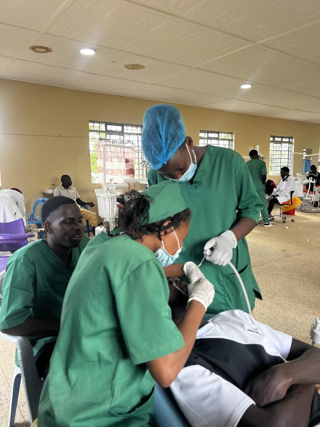 Ugandan dental students treating a patient under supervision
