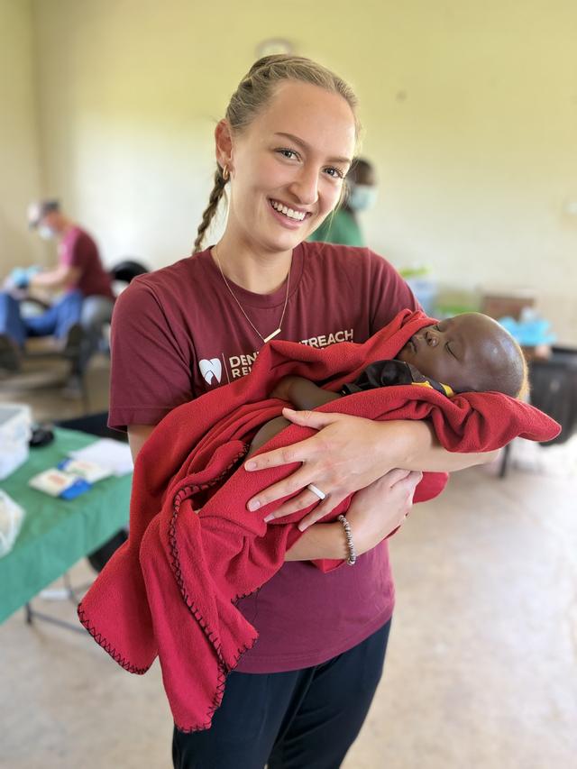 A volunteer holding a sleeping baby